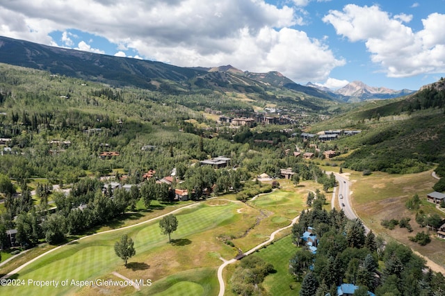 aerial view featuring a forest view, a mountain view, and golf course view