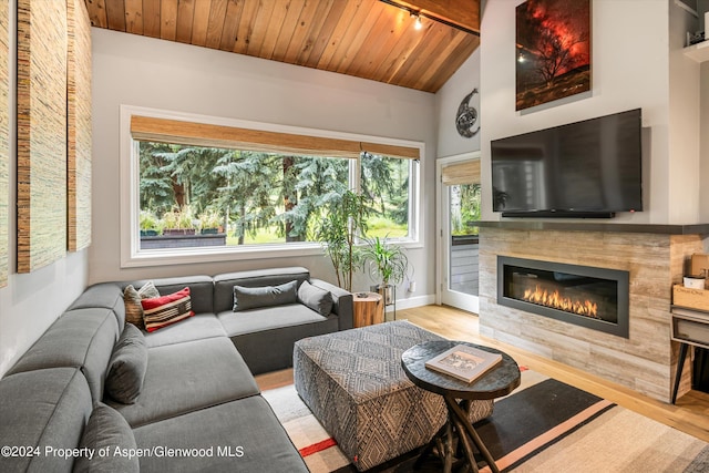 living room with vaulted ceiling with beams, wood ceiling, and light hardwood / wood-style flooring