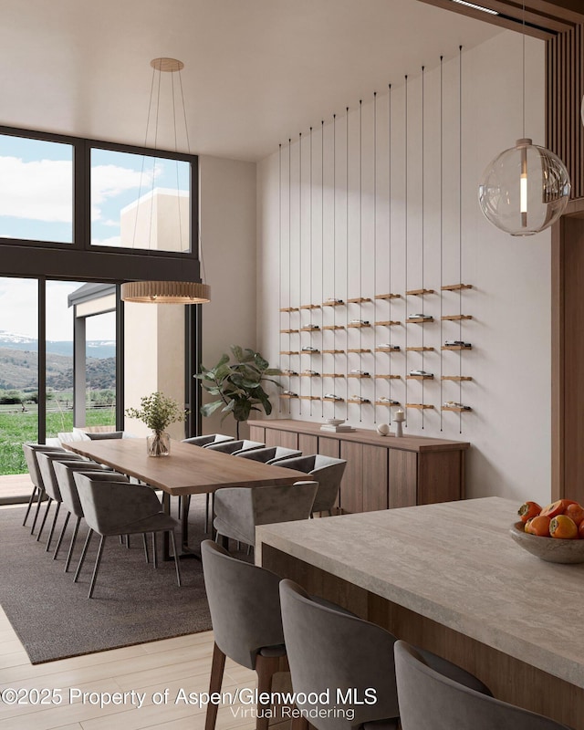 dining room with hardwood / wood-style flooring, expansive windows, and a high ceiling