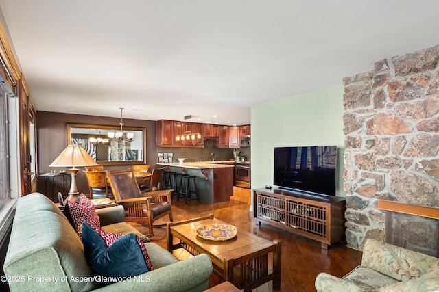 living area featuring an inviting chandelier and dark wood-type flooring
