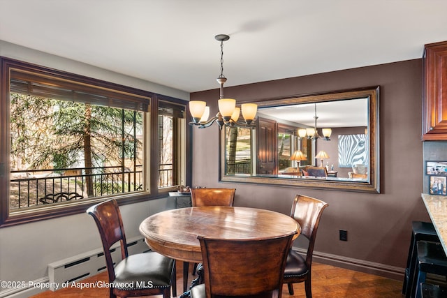 dining space featuring baseboards, baseboard heating, and a chandelier