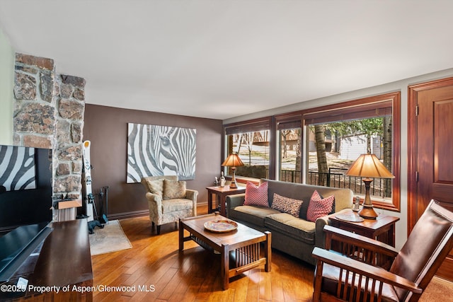 living area featuring baseboards and hardwood / wood-style flooring
