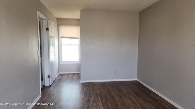 3863 W 6th St, Craig, CO 81625 - unfurnished room with dark wood finished floors, baseboards, and a textured ceiling