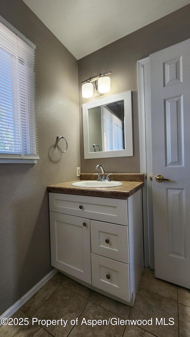 3863 W 6th St, Craig, CO 81625 - bathroom with vanity, tile patterned flooring, baseboards, and a textured wall