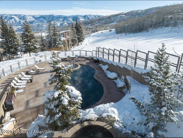 surrounding community featuring fence, a swimming pool, and a mountain view