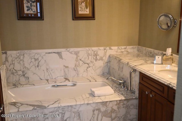 bathroom with vanity and a bath