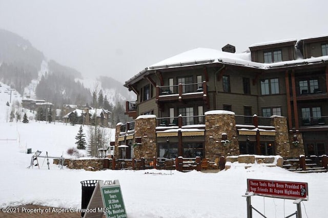 snow covered building featuring a mountain view