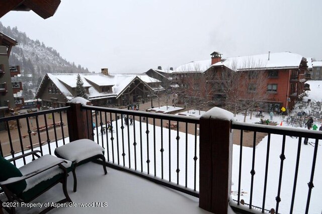 view of snow covered back of property