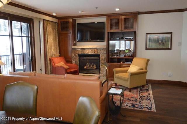 living room featuring a stone fireplace, dark hardwood / wood-style flooring, and ornamental molding