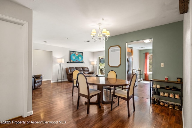 dining space featuring plenty of natural light, wood finished floors, and a chandelier