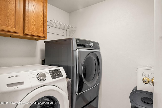 clothes washing area with cabinet space and washing machine and clothes dryer