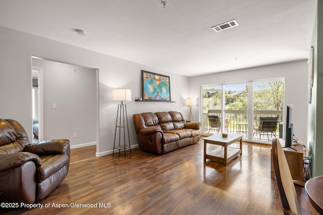 living room featuring baseboards, wood finished floors, and visible vents