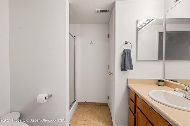 bathroom featuring toilet, visible vents, tile patterned flooring, a shower stall, and vanity