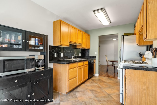 kitchen featuring tile counters, a sink, baseboards, tasteful backsplash, and appliances with stainless steel finishes
