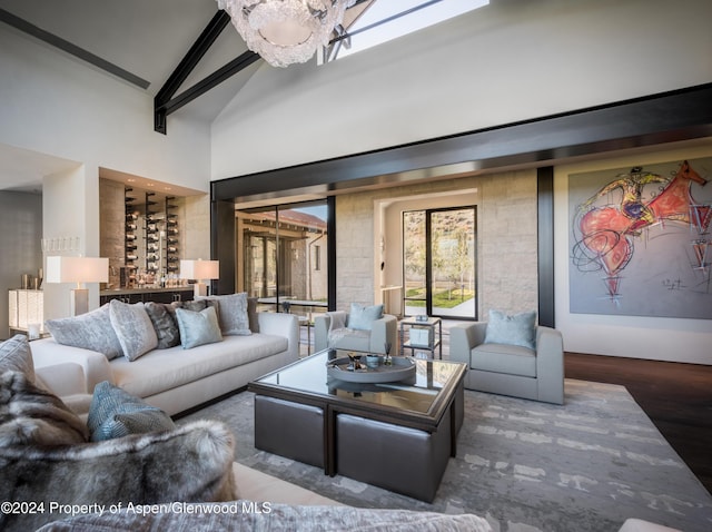 living room with a notable chandelier, beam ceiling, dark hardwood / wood-style flooring, and high vaulted ceiling