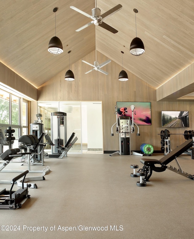 gym featuring ceiling fan, wood walls, wood ceiling, and high vaulted ceiling