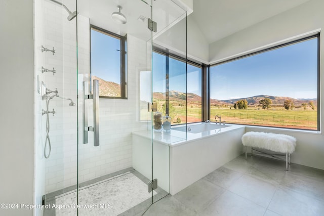 bathroom with separate shower and tub, a mountain view, tile patterned floors, and a rural view