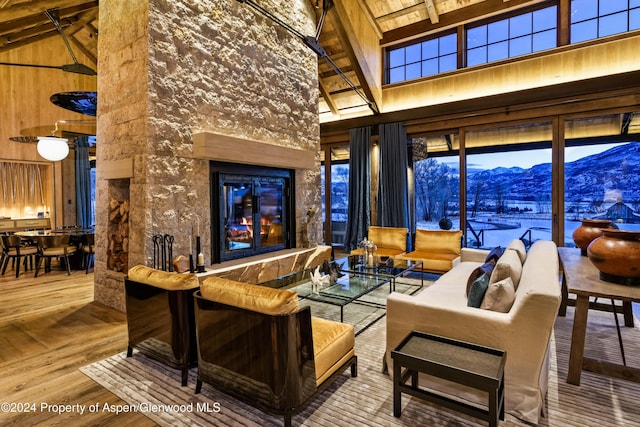 living room with a mountain view, wooden ceiling, high vaulted ceiling, beam ceiling, and wood-type flooring