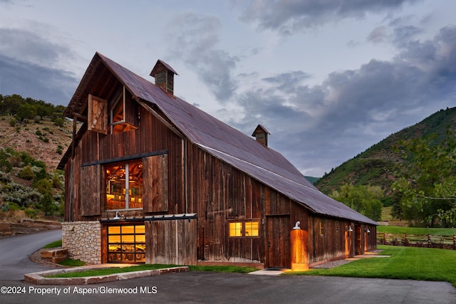 view of property exterior with a mountain view and an outdoor structure