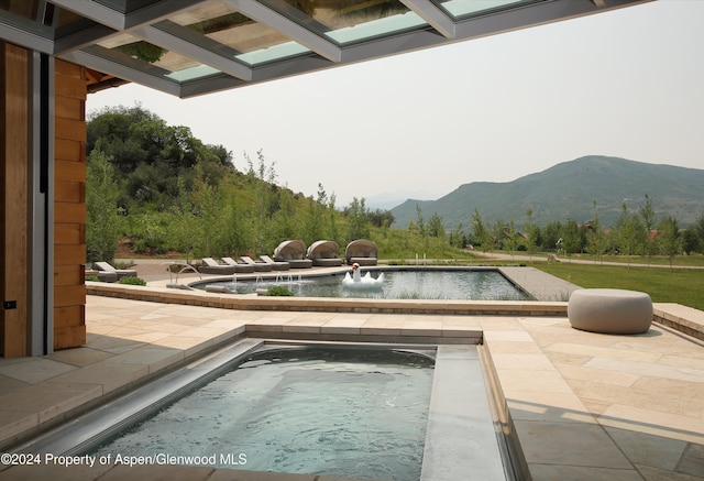 view of pool featuring a mountain view, a jacuzzi, and pool water feature