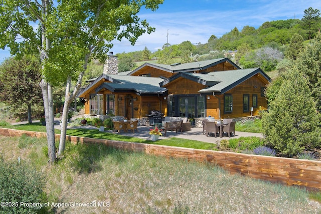 47 Mule Deer Run, Snowmass, CO 81654 - rear view of house with a chimney, a patio, and outdoor lounge area