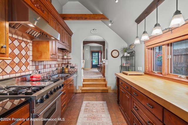 kitchen featuring appliances with stainless steel finishes, under cabinet range hood, wood counters, arched walkways, and decorative backsplash