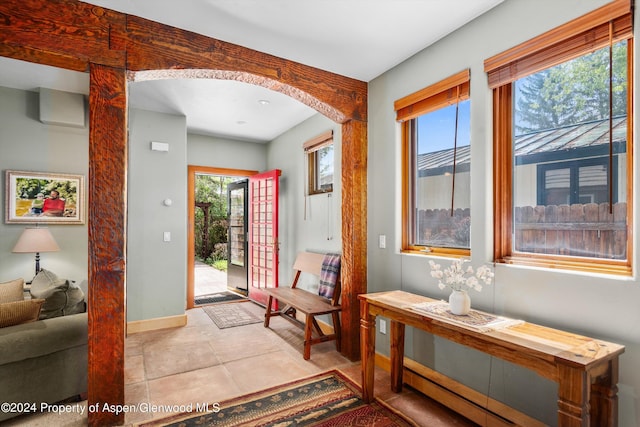 foyer entrance featuring arched walkways and baseboards