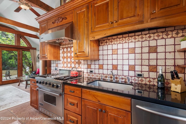 kitchen with appliances with stainless steel finishes, a sink, ventilation hood, brown cabinets, and dark countertops