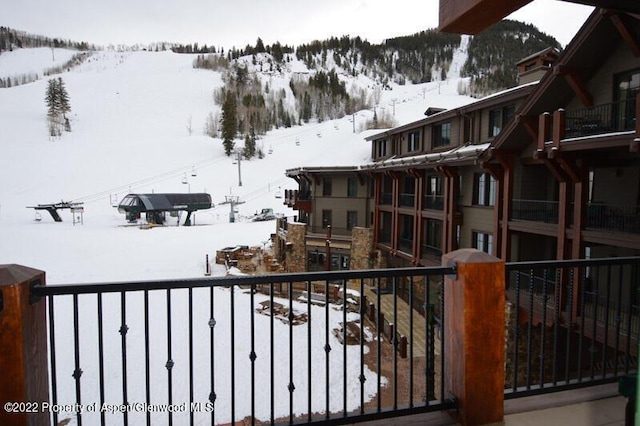 snow covered back of property with a mountain view