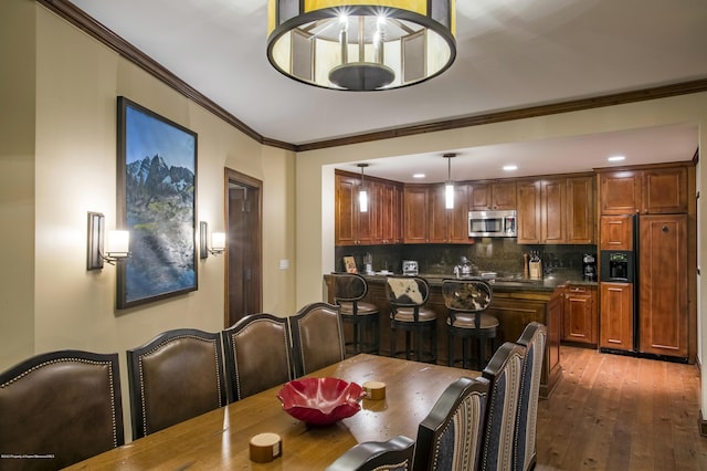 dining space with ornamental molding and dark hardwood / wood-style floors