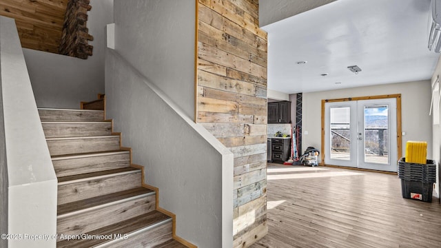 stairway featuring french doors and wood finished floors