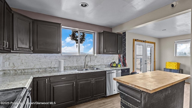 kitchen with wooden counters, tasteful backsplash, stainless steel dishwasher, stove, and a sink