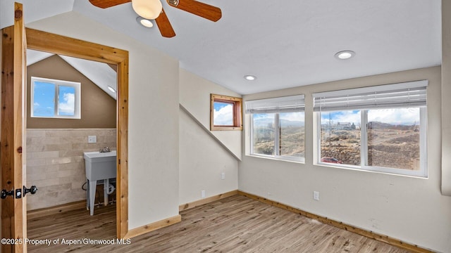 interior space with plenty of natural light, wood finished floors, and vaulted ceiling