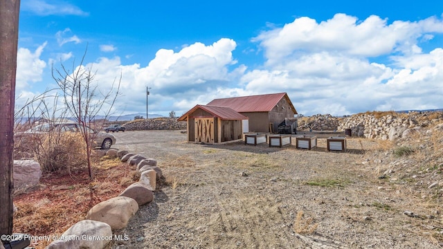 exterior space with a storage shed, an outbuilding, and metal roof