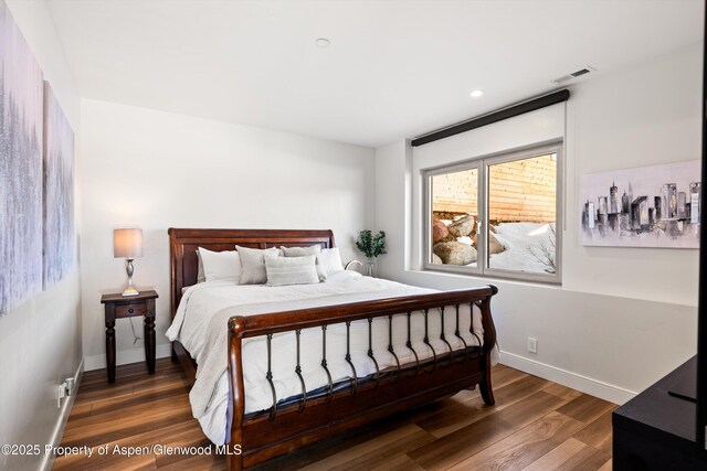 bedroom with recessed lighting, wood finished floors, visible vents, and baseboards