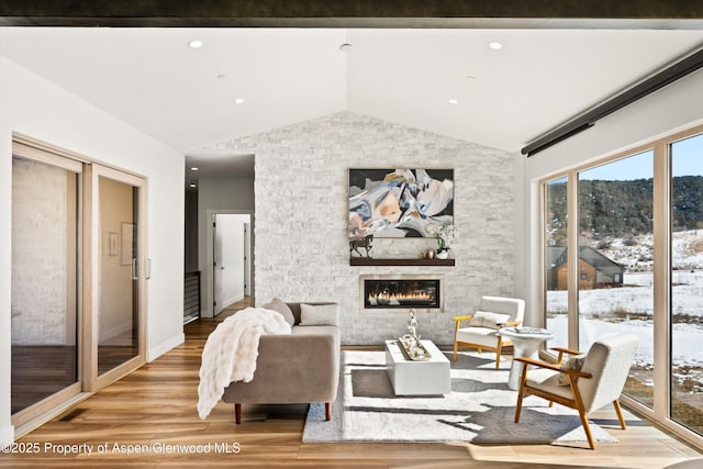 living room featuring a large fireplace, wood finished floors, lofted ceiling, and recessed lighting