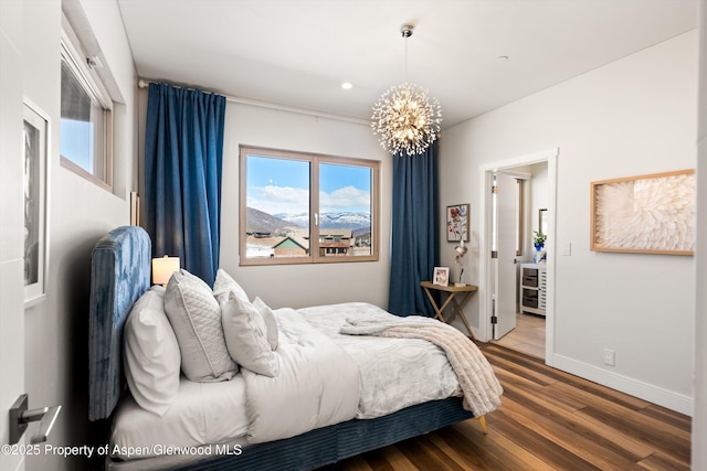 bedroom featuring an inviting chandelier, baseboards, wood finished floors, and recessed lighting