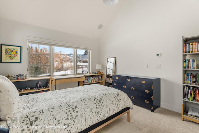 carpeted bedroom with high vaulted ceiling