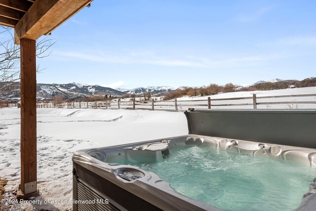 exterior space with a mountain view and a hot tub