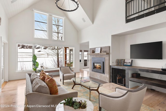 living room with a towering ceiling and light hardwood / wood-style floors