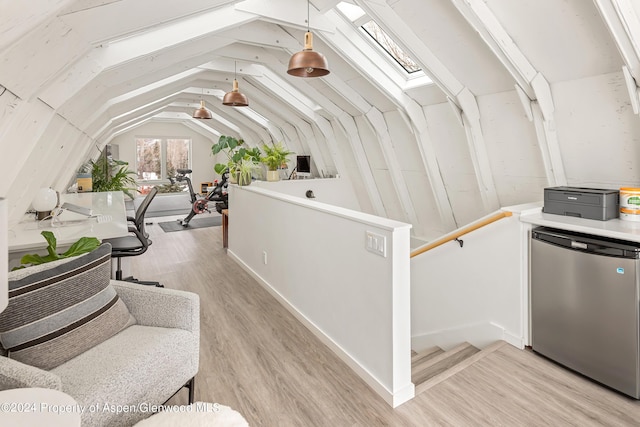 interior space with light wood-type flooring and vaulted ceiling