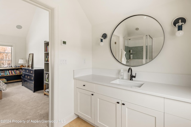 bathroom featuring vanity, vaulted ceiling, and a shower with door