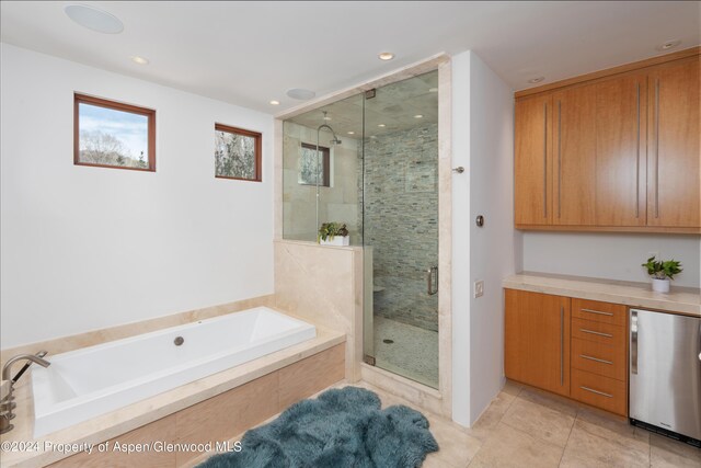 bathroom with a bath, recessed lighting, a shower stall, and tile patterned flooring