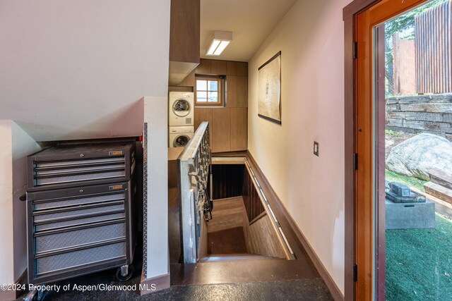 stairway featuring stacked washer / dryer and baseboards