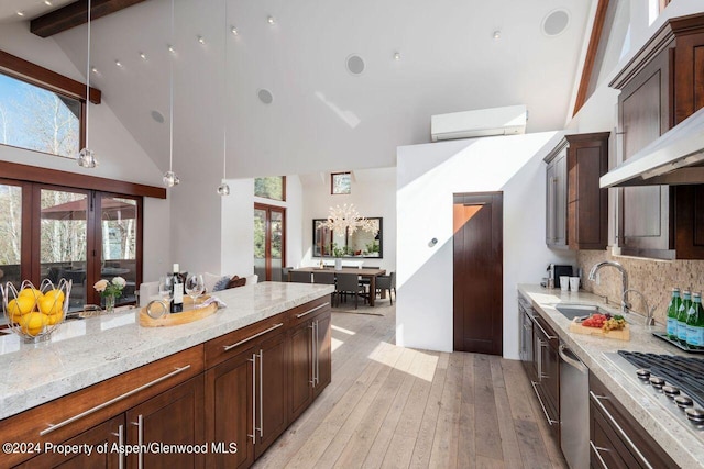 kitchen featuring a sink, a wall unit AC, stainless steel appliances, light wood-style floors, and wall chimney exhaust hood