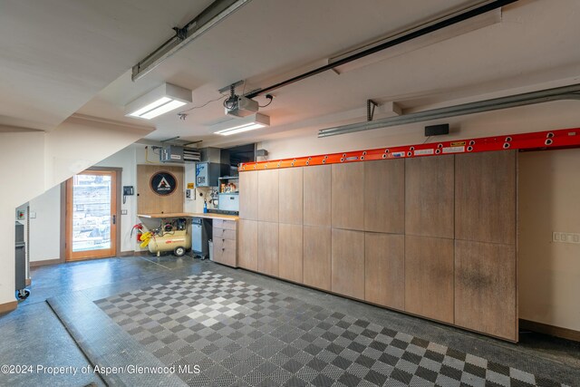 garage with baseboards and a garage door opener