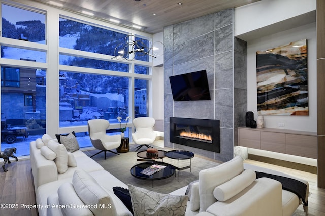 126 Juan St, Aspen, CO 81611 - living room featuring a fireplace, a chandelier, wooden ceiling, wood finished floors, and a wall of windows