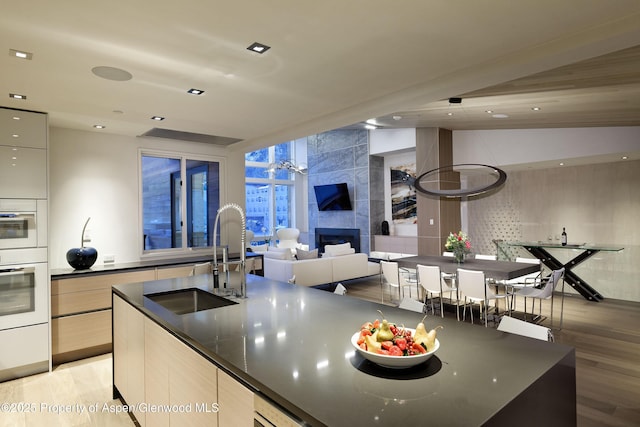 126 Juan St, Aspen, CO 81611 - kitchen with modern cabinets, light wood-type flooring, a tiled fireplace, open floor plan, and recessed lighting