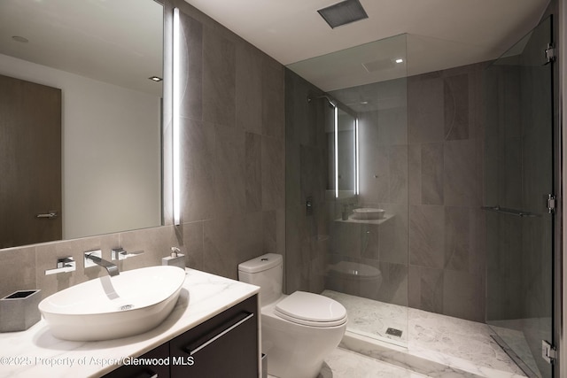 126 Juan St, Aspen, CO 81611 - bathroom with tile walls, a shower stall, vanity, and decorative backsplash