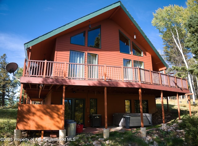 180 Ridge Rd, Gunnison, CO 81230 - back of property with a hot tub, a deck, and central AC
